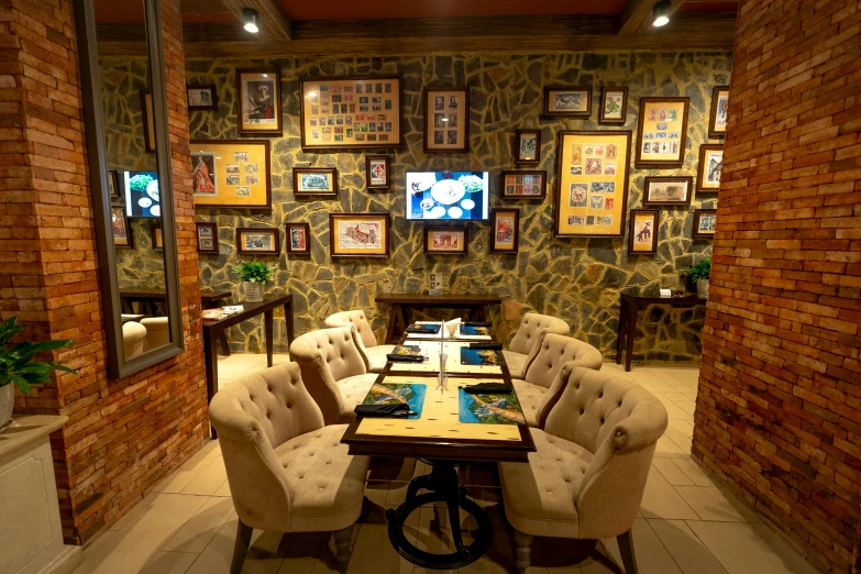 a room set up with tables and chairs with pictures on the walls