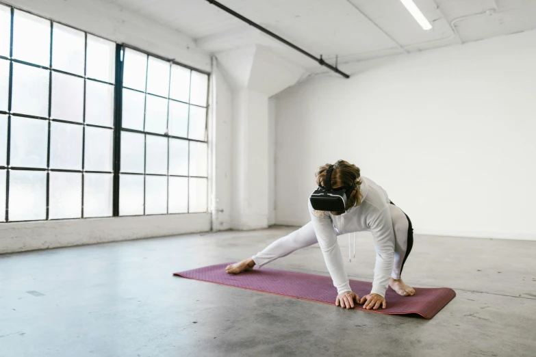 a woman in a yoga outfit stretches on her legs