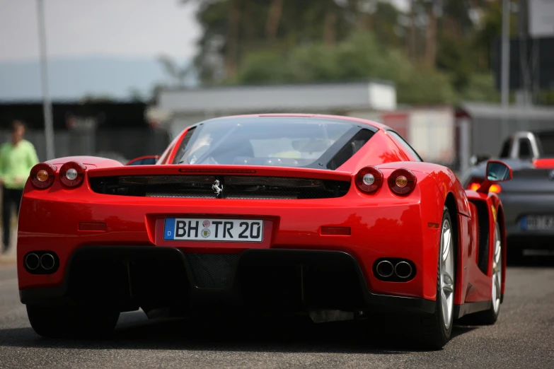 the ferrari is parked with other cars in the background