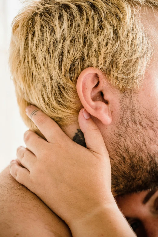 a close up of a person kissing a persons face