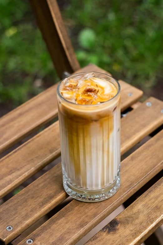 a drink is on a wooden table outside