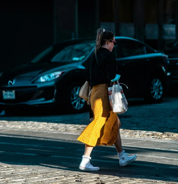 a woman with glasses on walking across the street