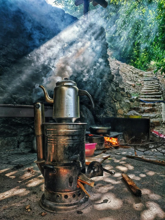a steel stove sitting next to a forest