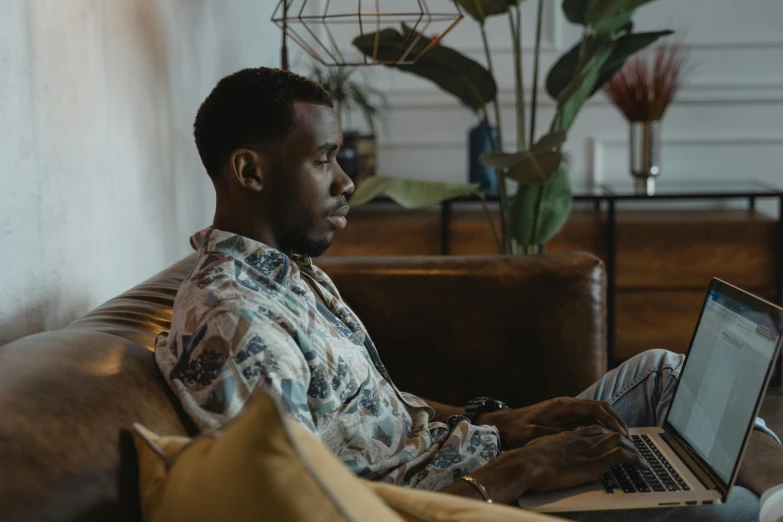 a man sitting on the couch with his laptop