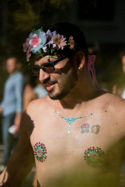 a man in a flower crown wearing some tattoos