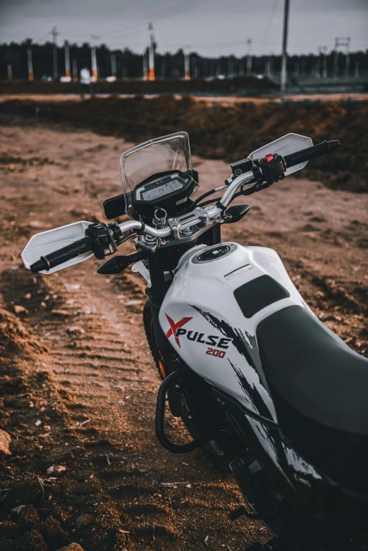 motorcycle parked on a dirt road with it's front ke missing