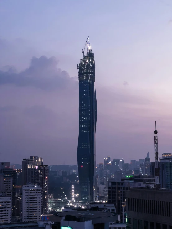 a very tall building near many buildings with the sky