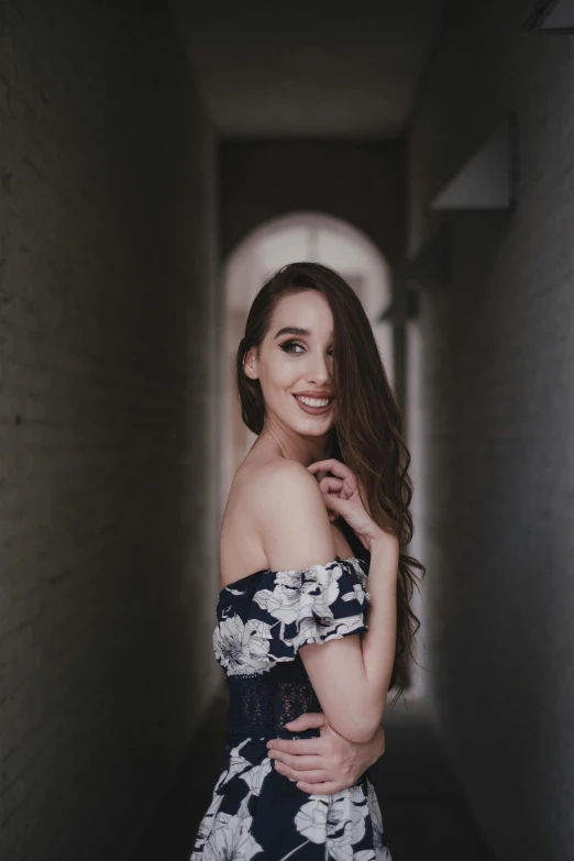 a woman is smiling at the camera in a floral dress