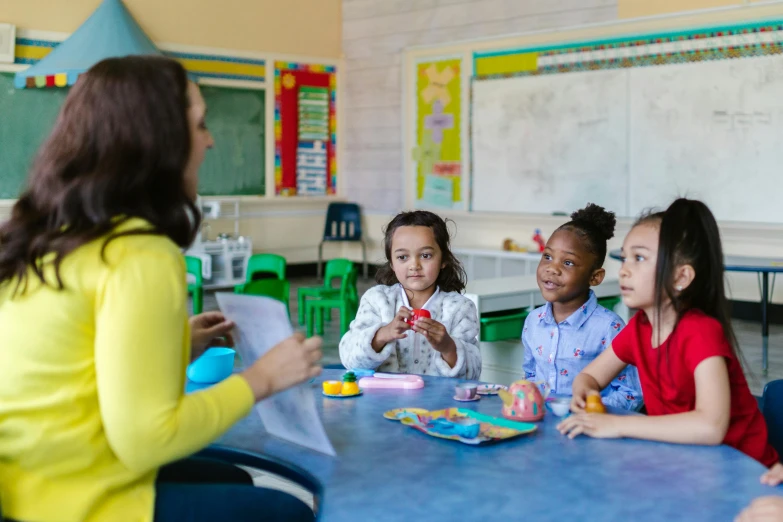 a group of children are sitting at a table and eating