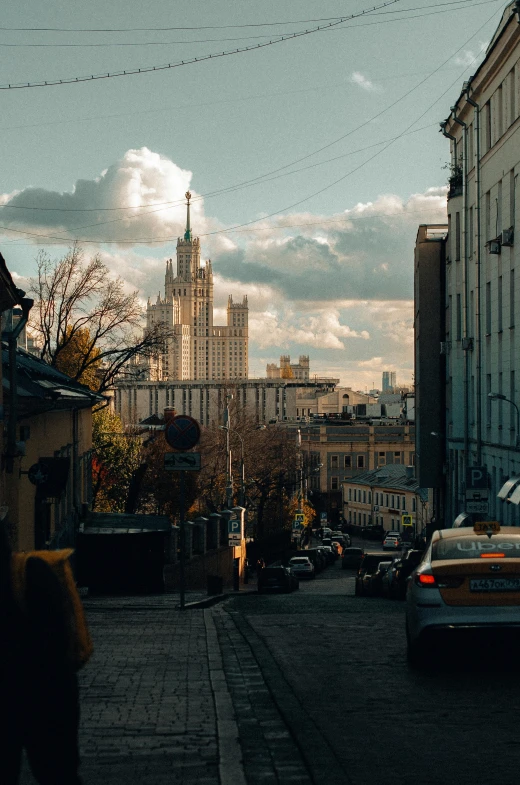 cars are traveling down a road near some buildings