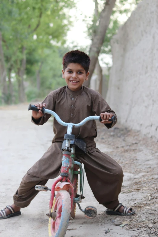 a  sitting on a bicycle while wearing a uniform