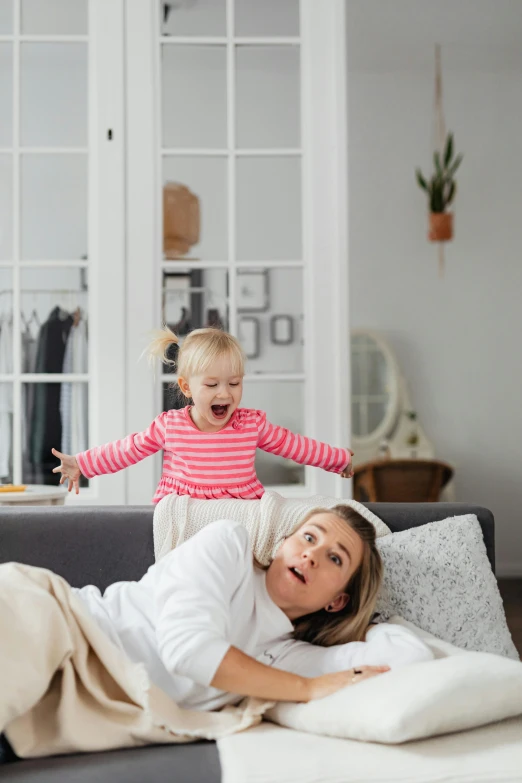 a mother and her daughter playing on the sofa