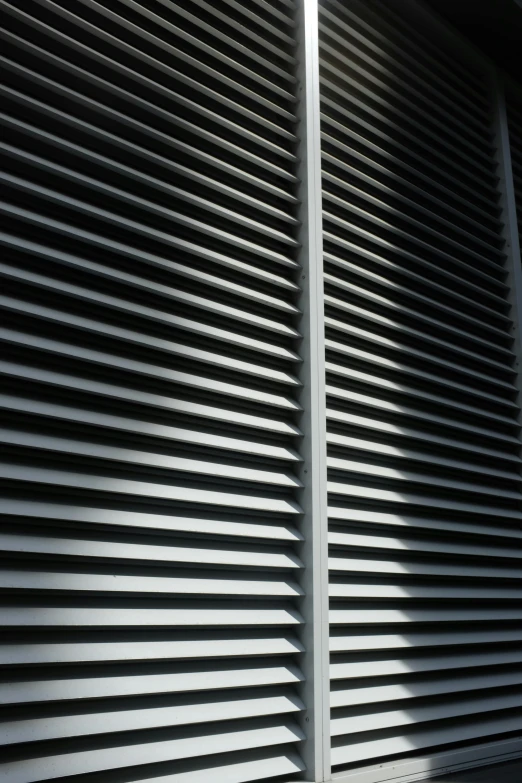 the shadows of blinds on a building's wall