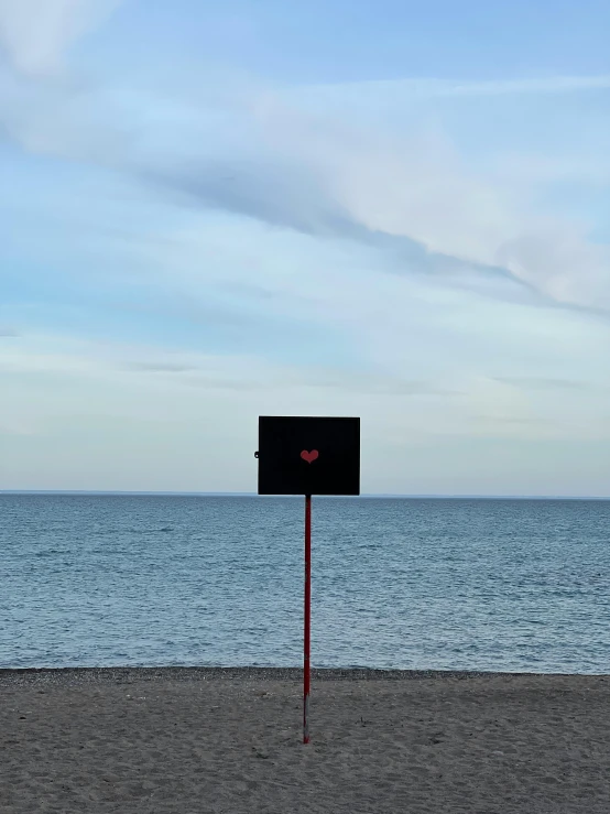 an empty box sits alone on the beach next to the ocean