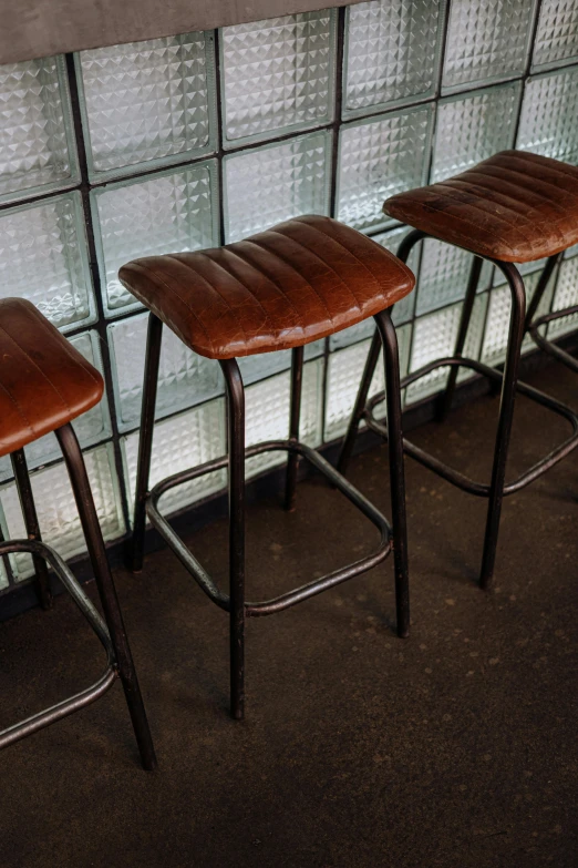 three barstools with a window behind them