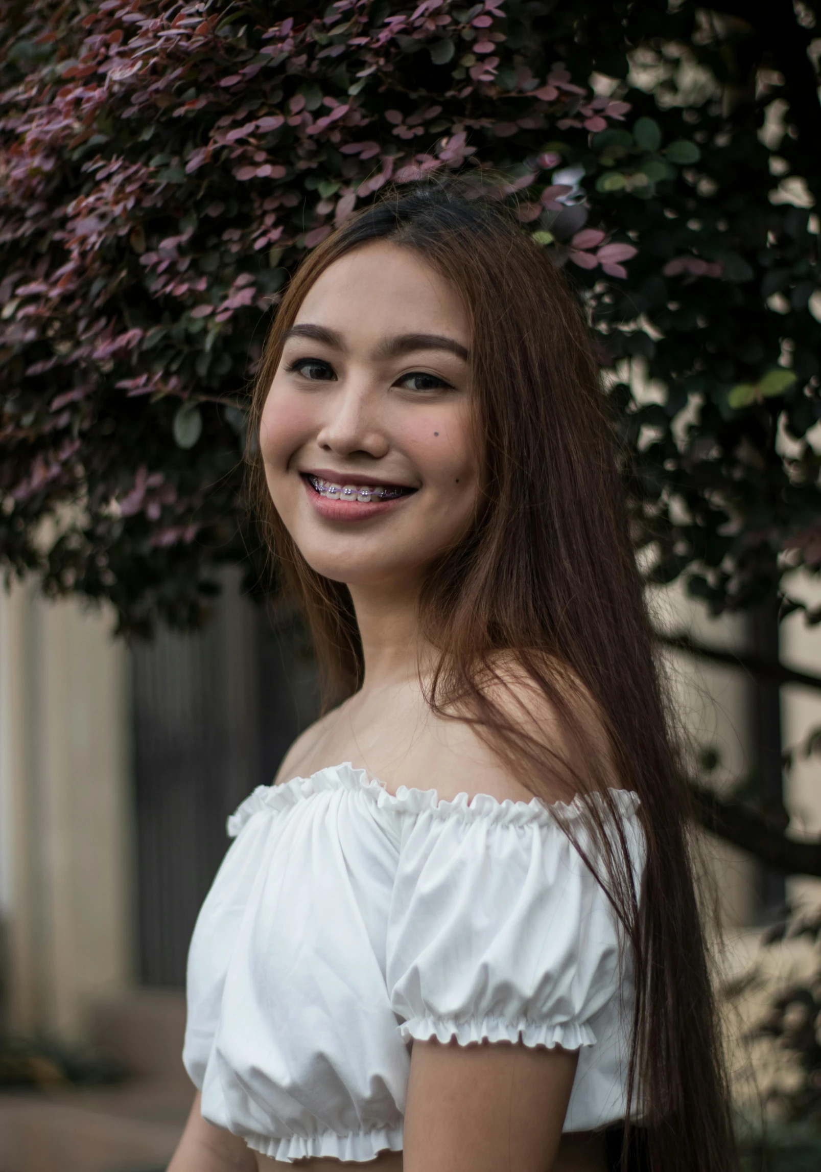 an asian woman in white smiles for the camera