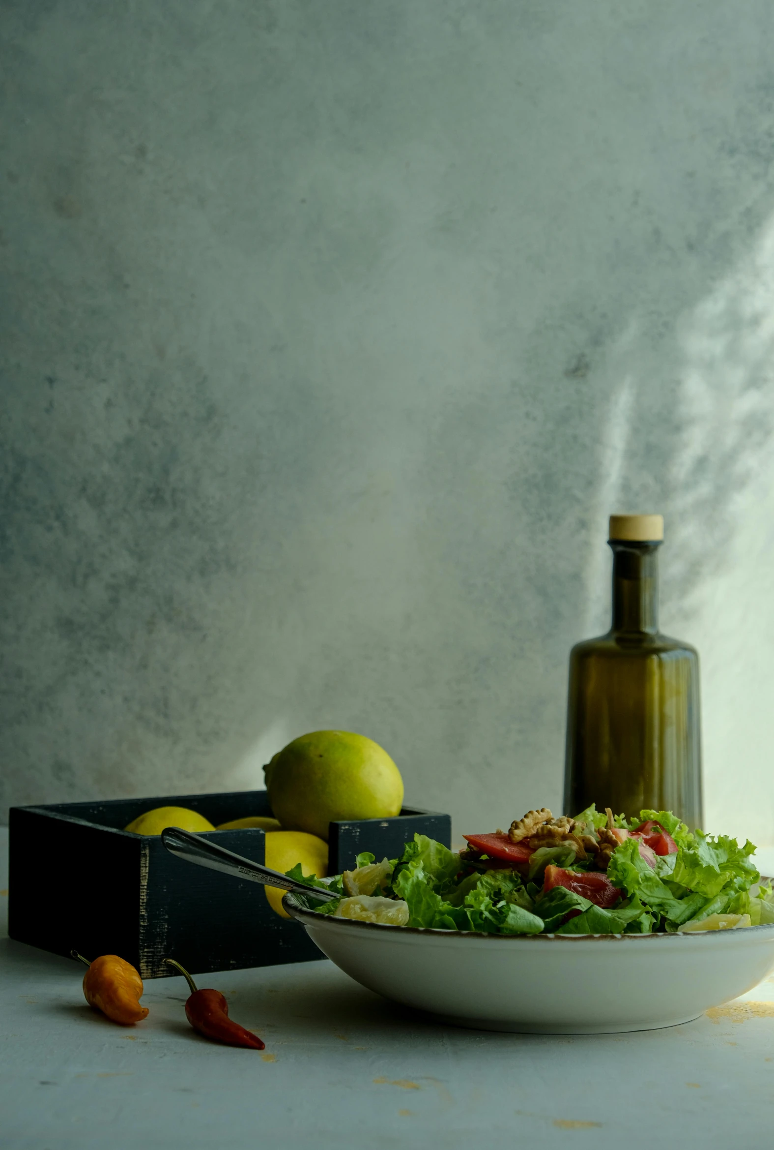 a bottle and an empty plate next to some vegetables