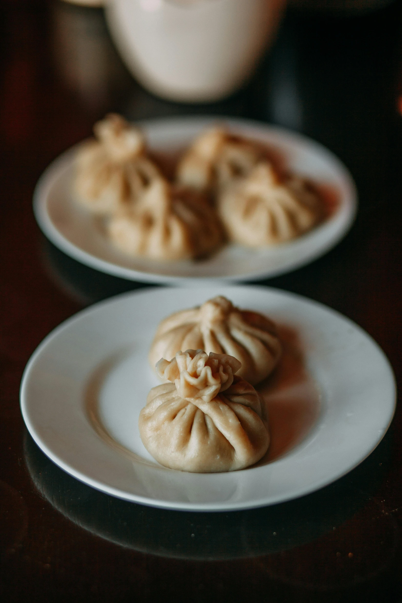 three small chinese buns with chinese writing on plates