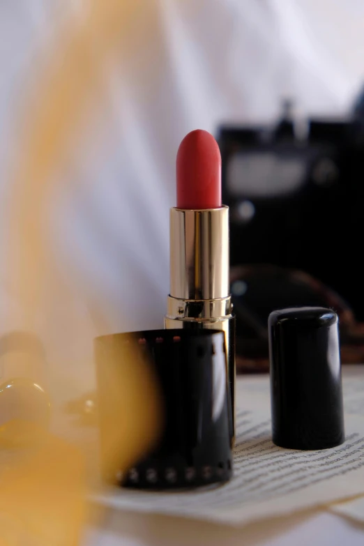 a pink lipstick in an elegant box sits upon a table