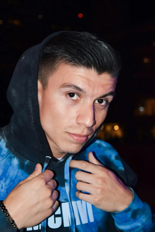 a young man that is wearing a blue and black hoodie