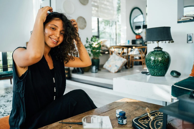 a woman sitting in front of a table next to a couch