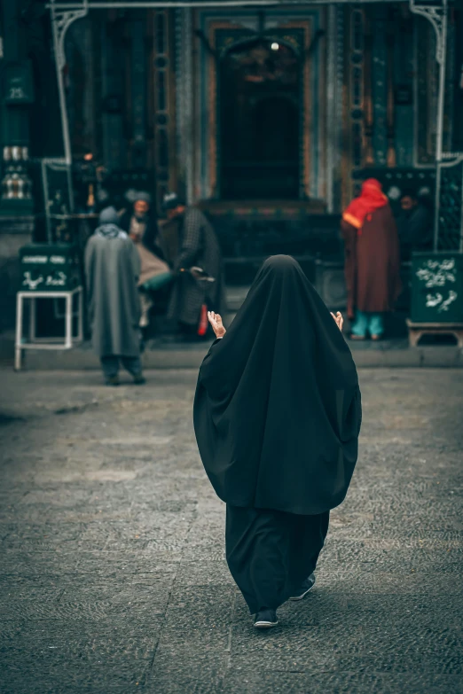 a woman dressed in an abal walking in the street