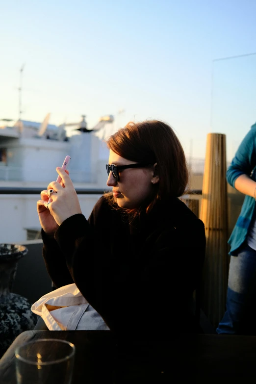 a woman sitting in front of a boat with a glass in her hands