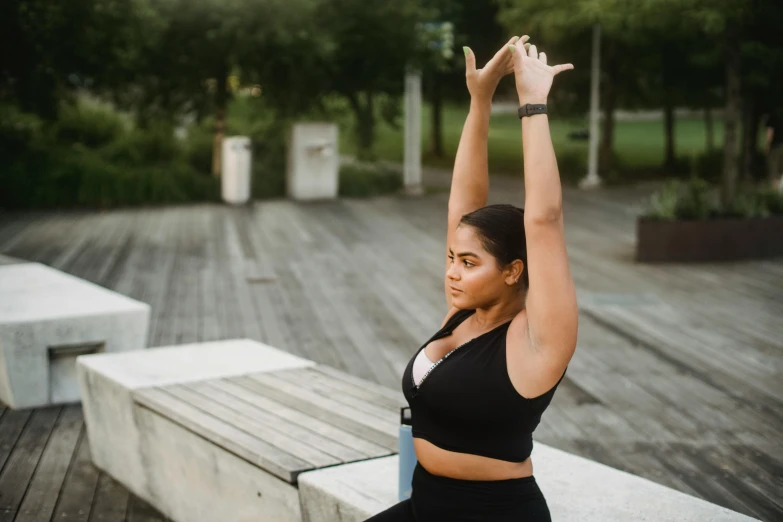 the young woman is practicing her yoga outside