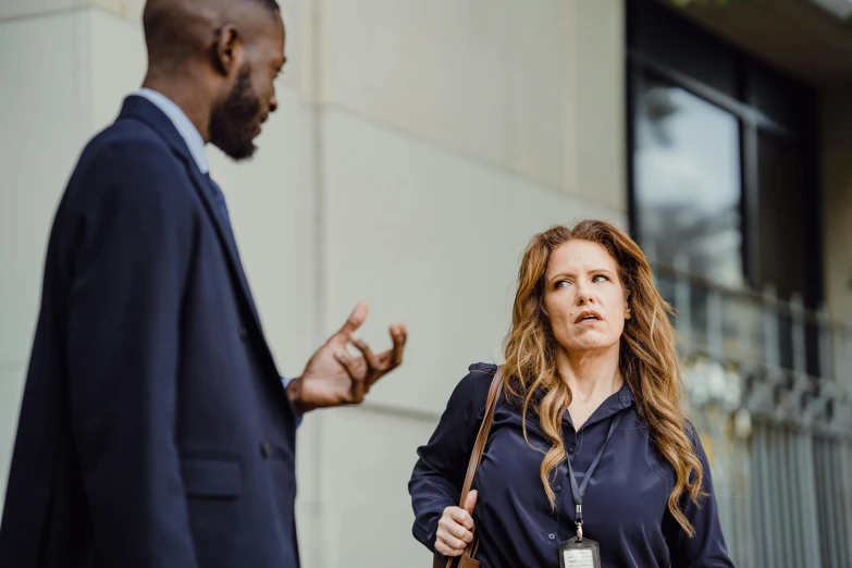 a woman standing in front of a man who is talking