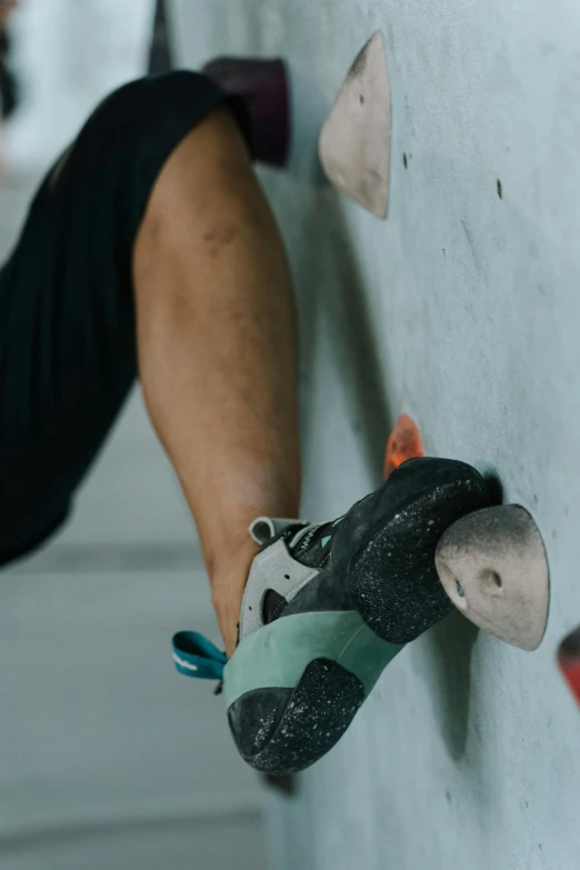 a man holds a climbing equipment on the face of a wall