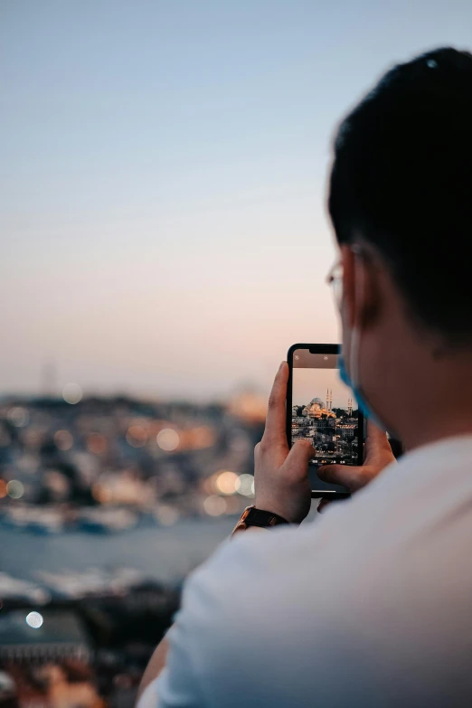 a person holding up their phone to take a po of the city