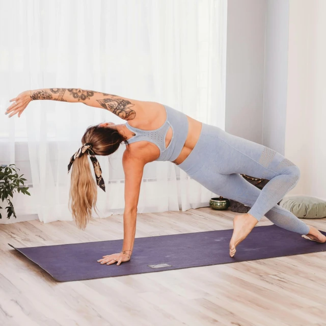 a young woman practices an acrobatic yoga pose