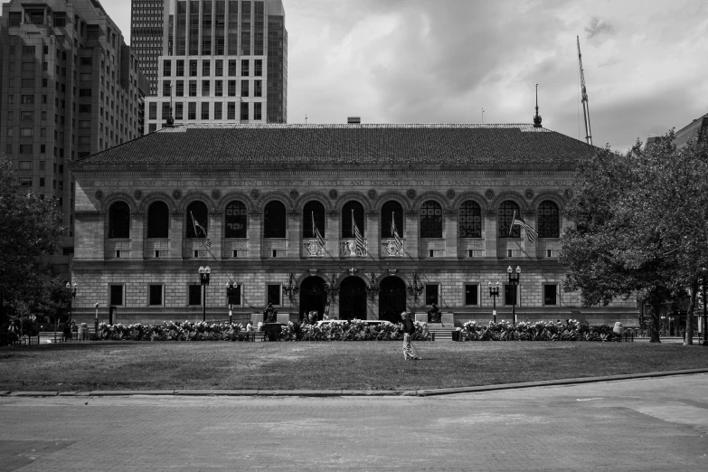 several people sitting on the bench in front of a large building