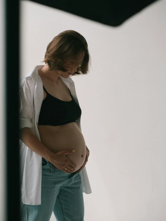 a pregnant woman is standing up to take a picture