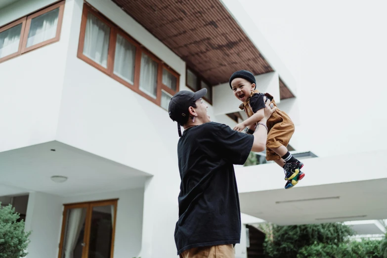 an older man holding up a young child while he holds him high in the air