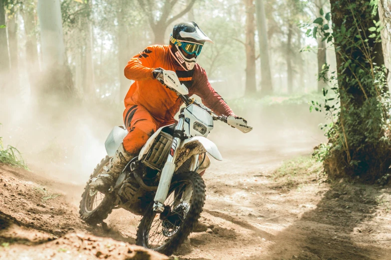 a man is riding a dirt bike on a trail