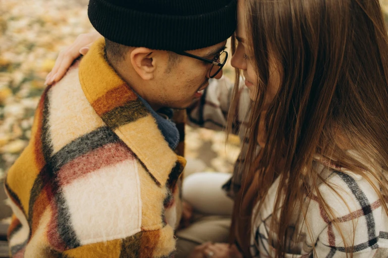 a couple sharing an emce in the fall leaves