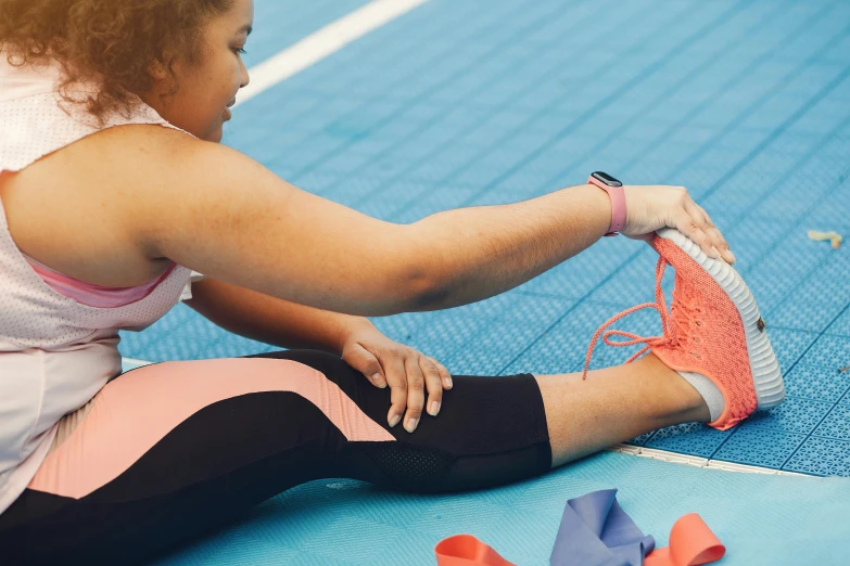 a woman tying shoes on the ground in preparation for a race