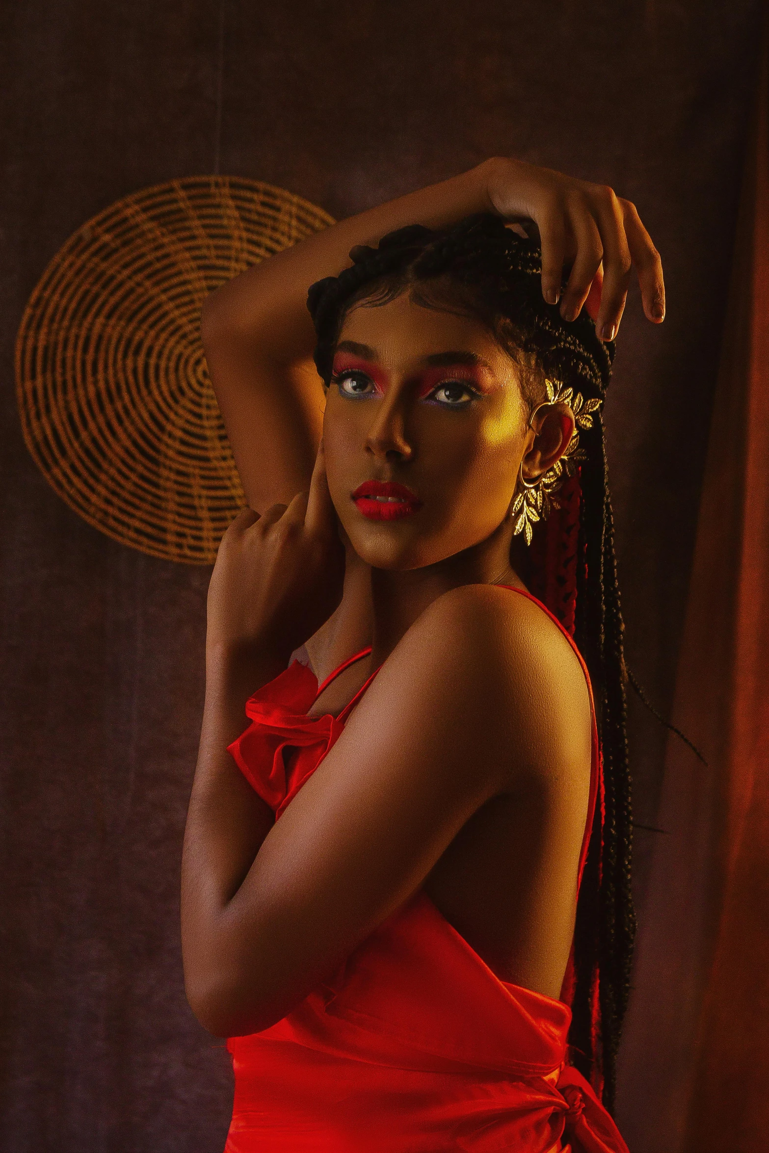 a woman in red holding her hand up to her hair