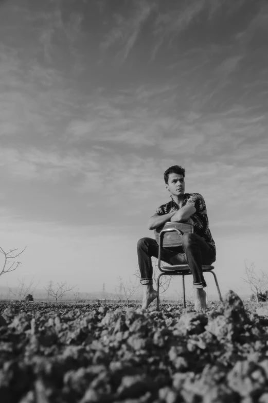 black and white pograph of a man sitting in a chair