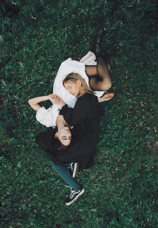 a man and a little girl laying in some grass