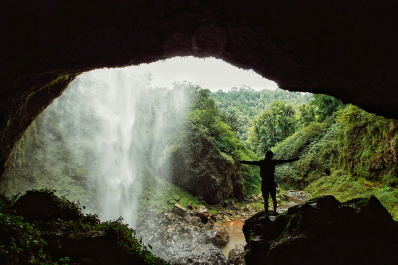 the silhouette of a person standing in a cave