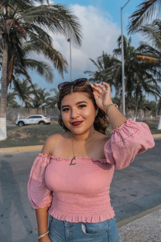 a beautiful woman wearing sunglasses standing in front of palm trees