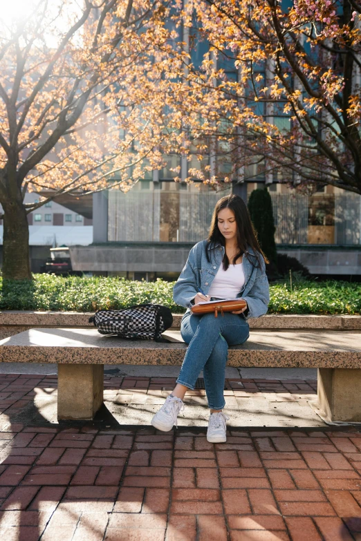 a girl is sitting on a bench in the city