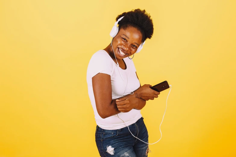 the smiling woman in white shirt and jeans holds a remote control