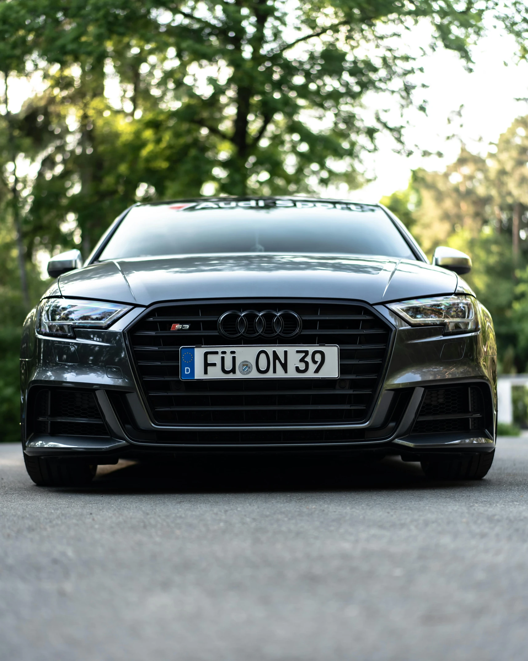 the front view of a black car parked on the street