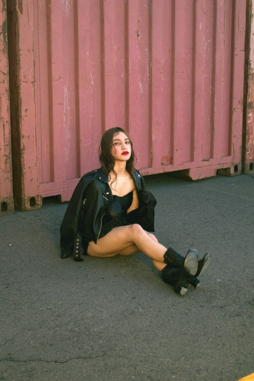 a woman in black clothing sitting in the street