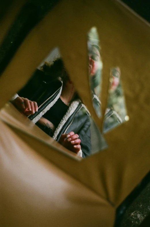 a young man standing behind a mirror looking at himself