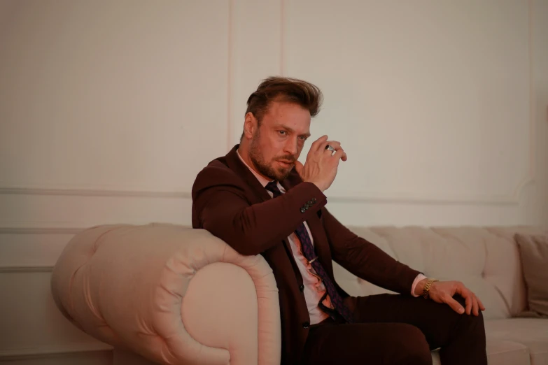 a man sits on a couch and smokes a cigarette