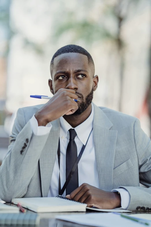 a black man in business attire smoking a cigarette